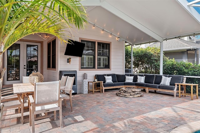 view of patio / terrace featuring an outdoor living space with a fire pit and french doors