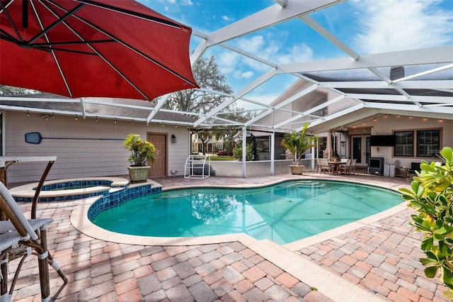 view of swimming pool featuring an in ground hot tub, a lanai, and a patio area