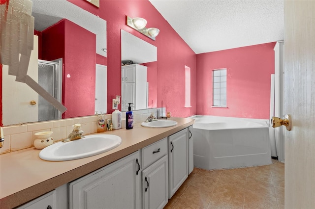 bathroom with tile patterned floors, separate shower and tub, vaulted ceiling, a textured ceiling, and vanity