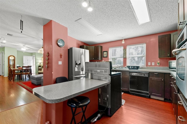 kitchen with stainless steel fridge with ice dispenser, light hardwood / wood-style floors, dishwasher, and a kitchen island