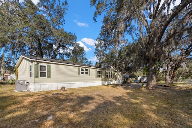 exterior space with central AC and a yard