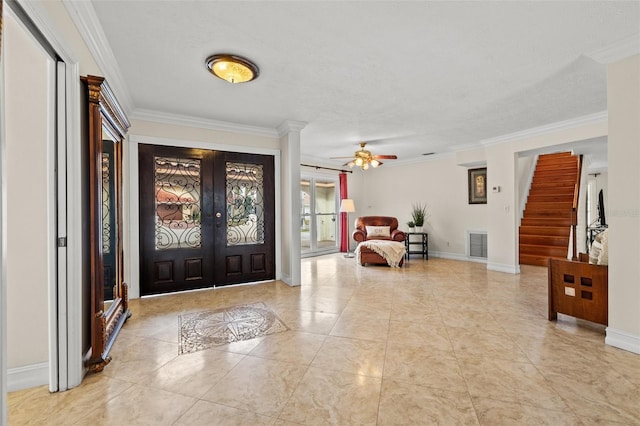 entryway featuring crown molding, light tile patterned floors, a textured ceiling, and french doors