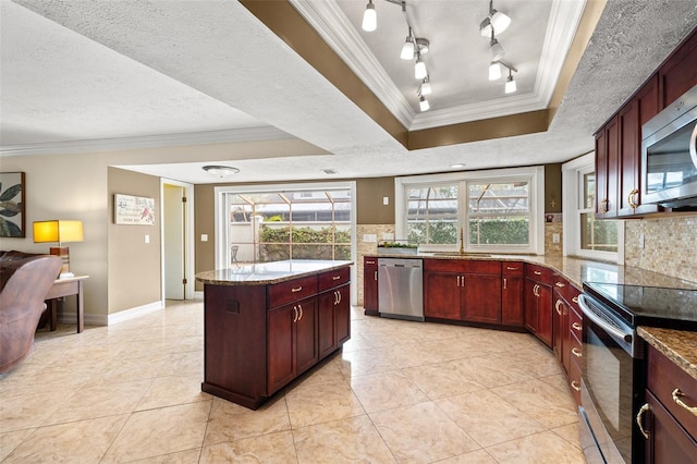 kitchen featuring appliances with stainless steel finishes, light stone countertops, a textured ceiling, decorative backsplash, and a raised ceiling