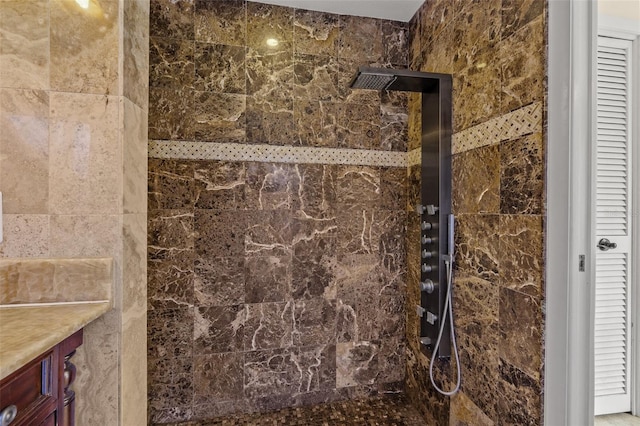 bathroom with vanity and a tile shower