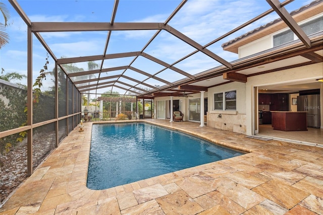 view of pool featuring glass enclosure and a patio area