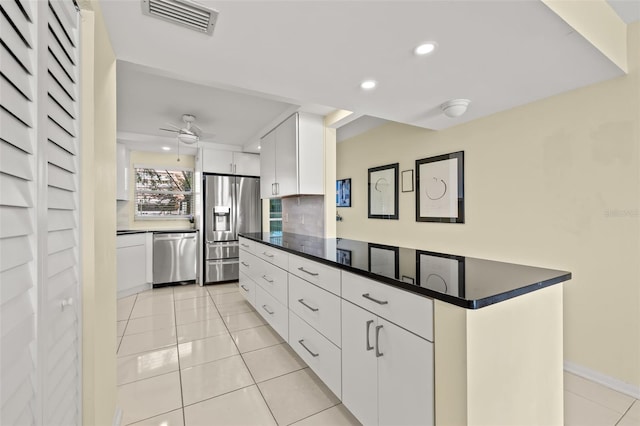 kitchen featuring light tile patterned floors, ceiling fan, backsplash, stainless steel appliances, and white cabinets