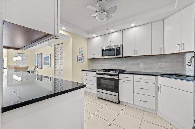 kitchen featuring light tile patterned flooring, stainless steel appliances, backsplash, and white cabinets