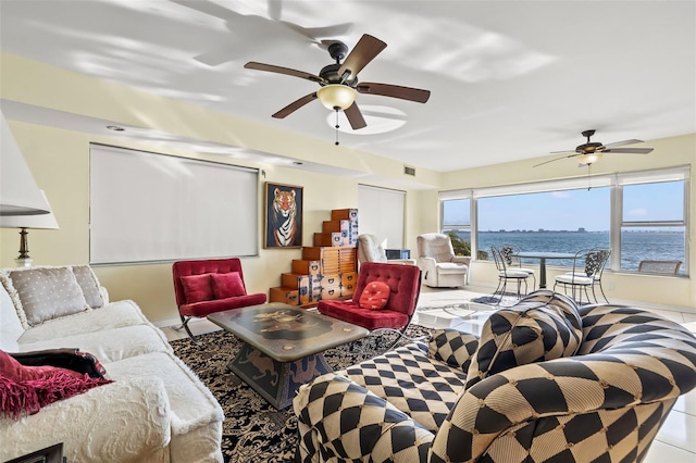 living room with a water view, light tile patterned floors, and ceiling fan