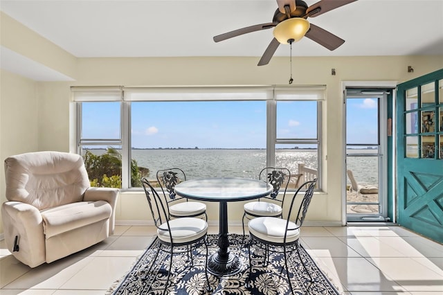 sunroom featuring ceiling fan and a water view