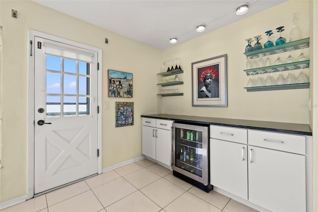 bar featuring wine cooler, light tile patterned flooring, and white cabinets