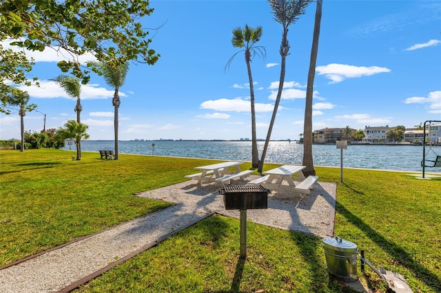 view of property's community featuring a lawn and a water view