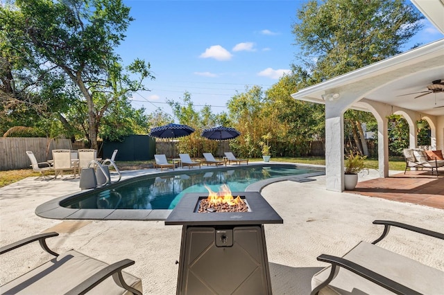 view of pool featuring a patio area, ceiling fan, and a fire pit