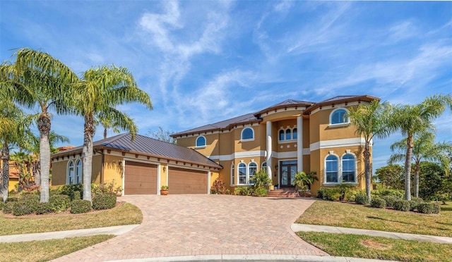 mediterranean / spanish-style house featuring a garage and a front yard