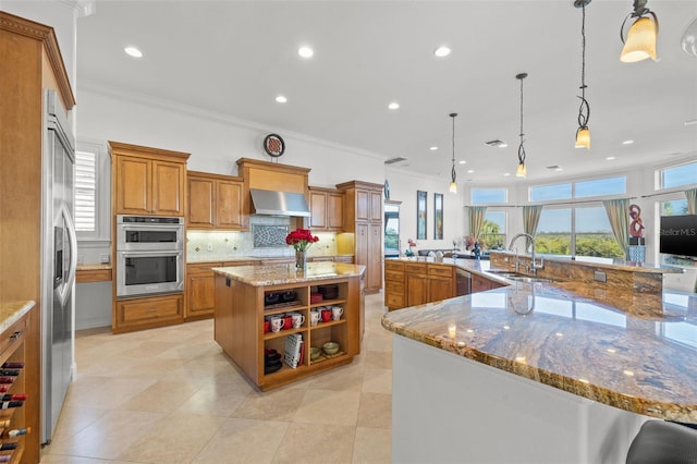 kitchen featuring pendant lighting, a large island, sink, stainless steel appliances, and extractor fan