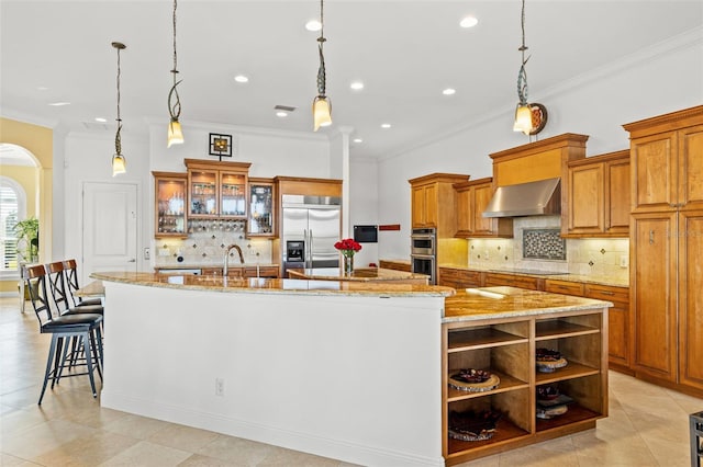 kitchen featuring a large island, pendant lighting, wall chimney exhaust hood, and appliances with stainless steel finishes