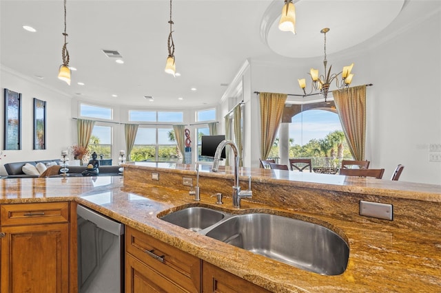 kitchen featuring light stone counters, stainless steel dishwasher, sink, and hanging light fixtures