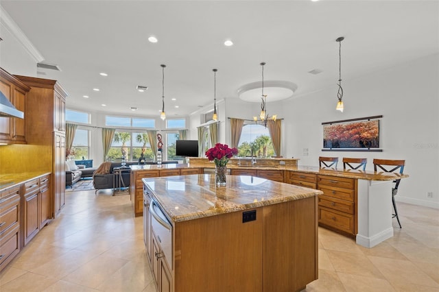 kitchen featuring a kitchen breakfast bar, hanging light fixtures, a large island, kitchen peninsula, and light stone countertops