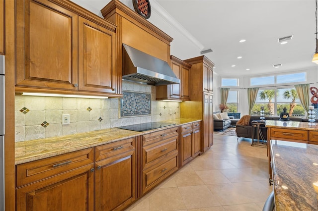 kitchen featuring decorative light fixtures, tasteful backsplash, light stone countertops, wall chimney range hood, and black electric cooktop