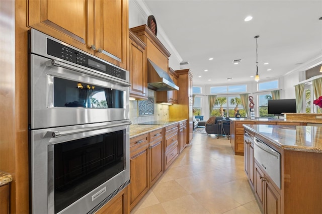 kitchen featuring crown molding, double oven, light stone counters, and exhaust hood