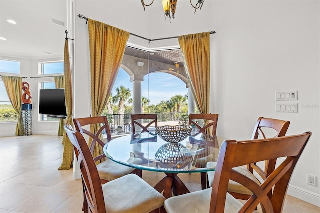 tiled dining area with a healthy amount of sunlight and a notable chandelier