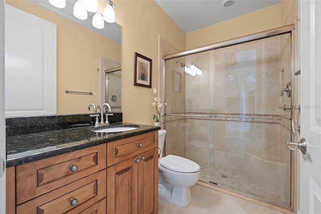 bathroom with vanity, toilet, a shower with shower door, and tile patterned flooring