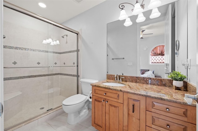 bathroom featuring vanity, tile patterned floors, a shower with door, and toilet