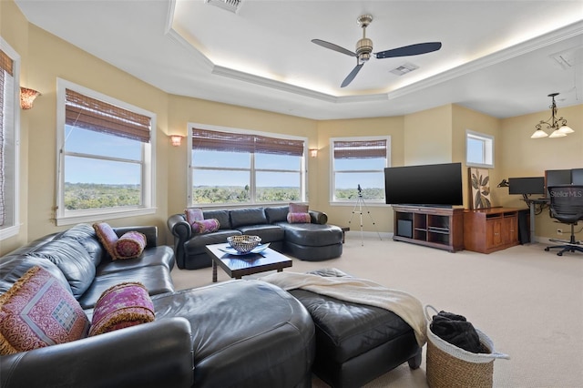 carpeted living room with a healthy amount of sunlight, ceiling fan, and a tray ceiling