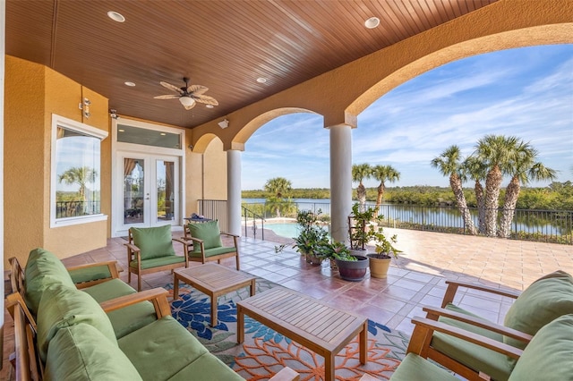 view of patio / terrace with an outdoor hangout area, ceiling fan, a fenced in pool, a water view, and french doors