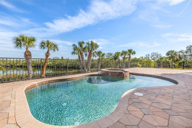 view of pool featuring an in ground hot tub, a water view, and a patio