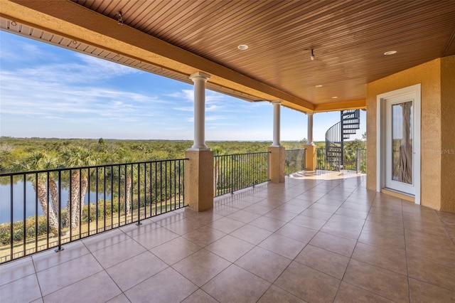 view of patio with a balcony and a water view