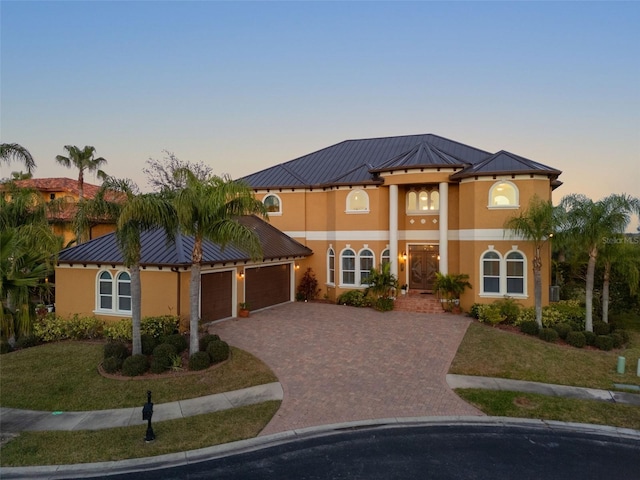 view of front of property with a garage and a lawn