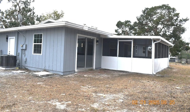 rear view of house featuring central AC unit and a sunroom