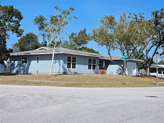 single story home with a garage and a front lawn