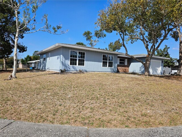 ranch-style home with a garage and a front lawn