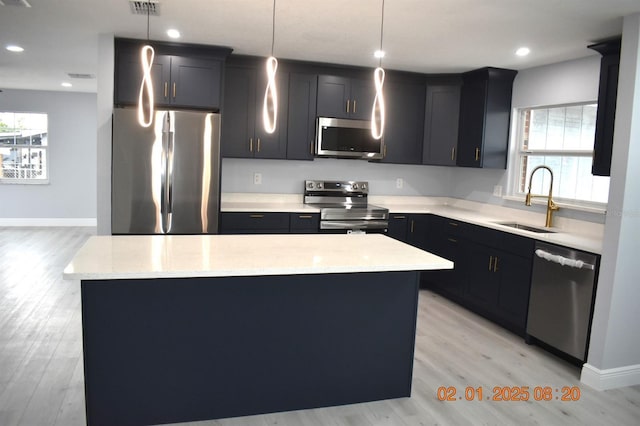 kitchen with pendant lighting, a center island, and appliances with stainless steel finishes