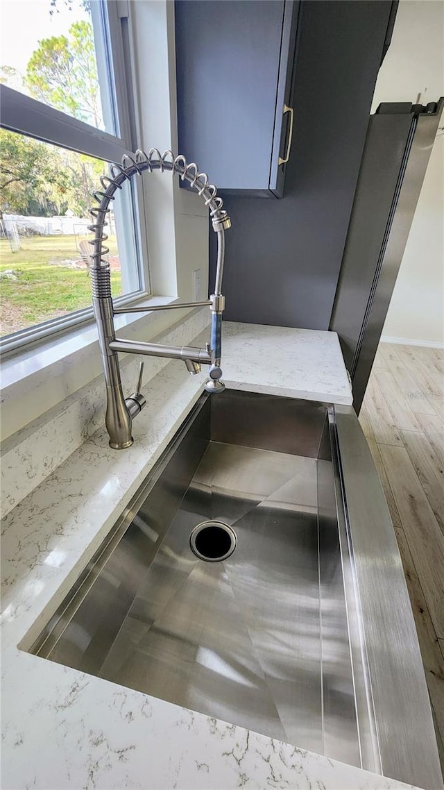 details featuring light stone counters and sink