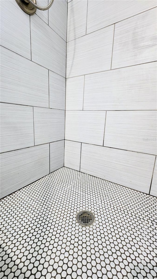 interior details with a tile shower