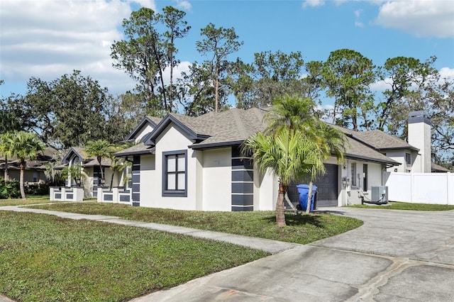 view of front facade featuring a garage, a front yard, and central air condition unit