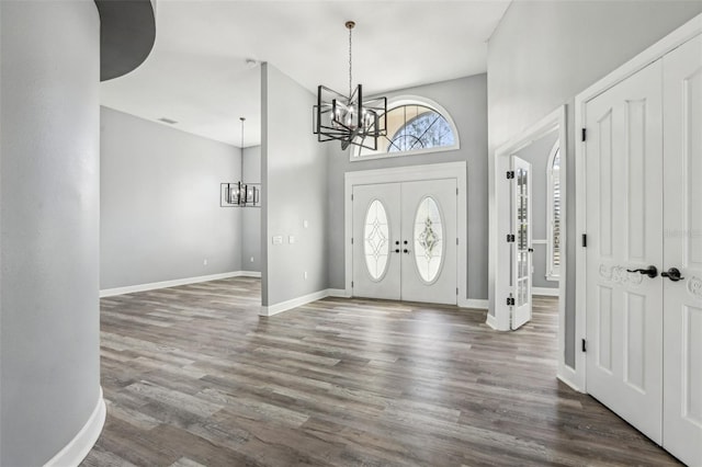 entryway with dark hardwood / wood-style flooring and a notable chandelier