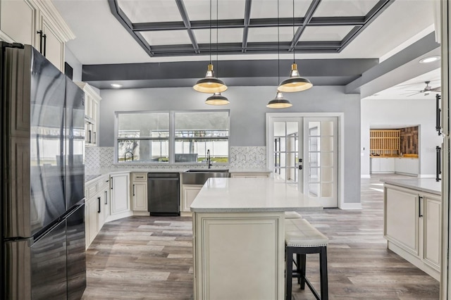 kitchen with pendant lighting, sink, fridge, tasteful backsplash, and a kitchen island