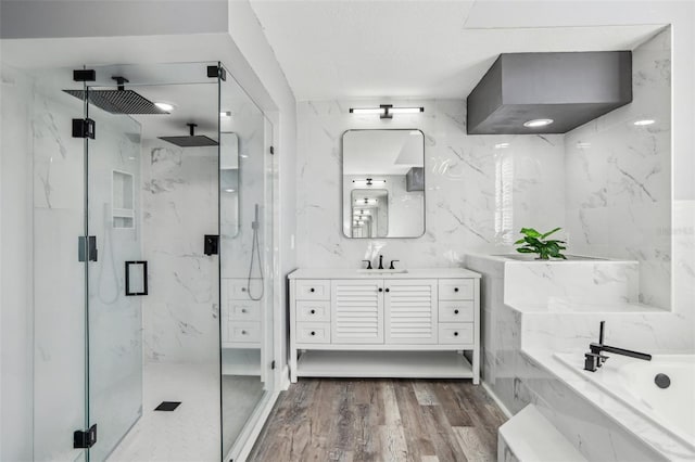 bathroom featuring hardwood / wood-style flooring, vanity, and shower with separate bathtub