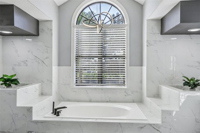 bathroom with a relaxing tiled tub