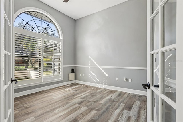 empty room featuring hardwood / wood-style floors, plenty of natural light, and french doors