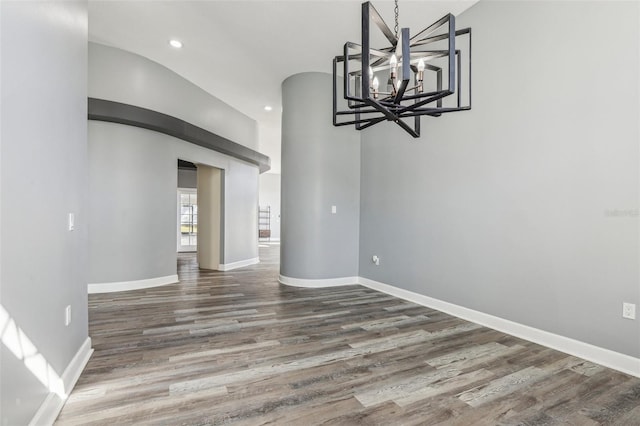 unfurnished dining area featuring dark hardwood / wood-style flooring and a chandelier