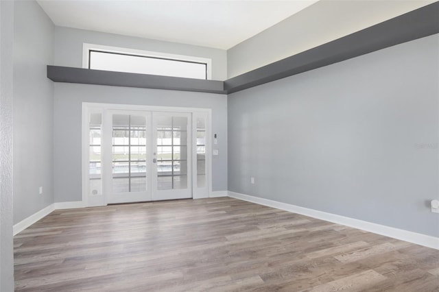 empty room with light wood-type flooring and french doors