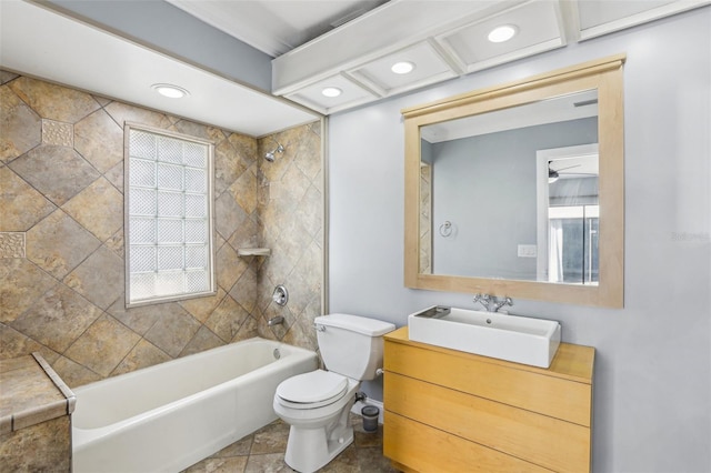 full bathroom featuring tiled shower / bath combo, vanity, ceiling fan, and toilet