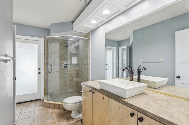 bathroom with vanity, tile patterned flooring, toilet, and walk in shower