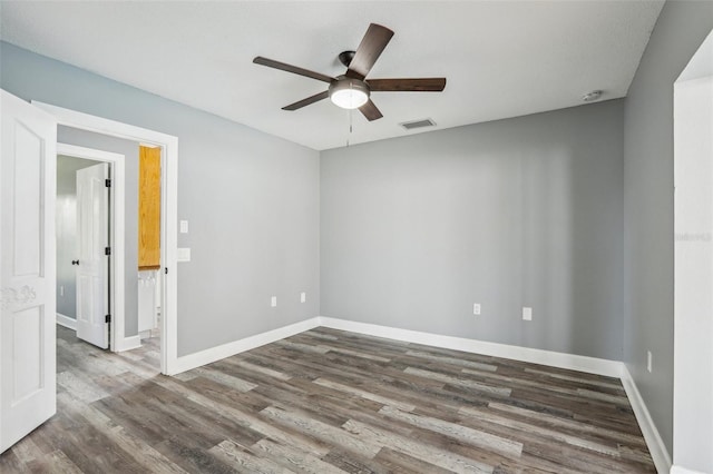 unfurnished room with ceiling fan and dark hardwood / wood-style flooring