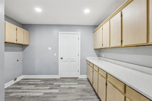 laundry area featuring cabinets, electric dryer hookup, and light wood-type flooring