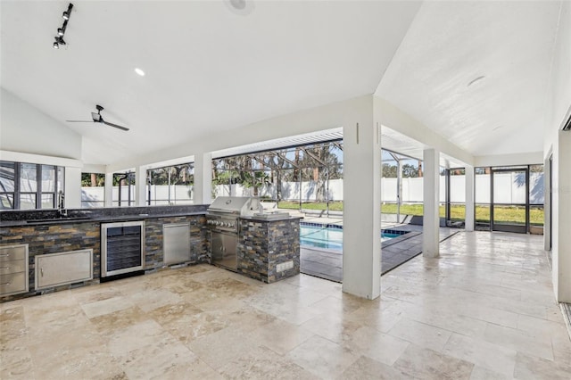 exterior space with lofted ceiling, sink, fridge, kitchen peninsula, and beverage cooler